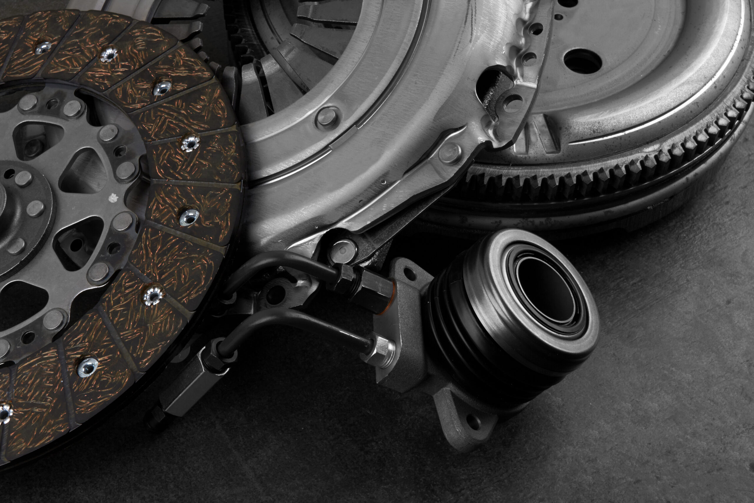 Car engine clutch on black stone surface